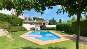 A rectangular swimming pool with a diving board, surrounded by well-maintained grass and a stone wall. - Casa Tossa – Pool, Parking & Terrace (27) (Tossa De Mar)
