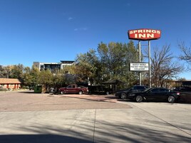 Letrero del A Springs Inn con servicios que incluyen WiFi gratuito, televisión por cable gratis y lavandería automática.