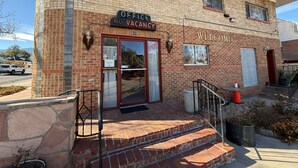 A two-story building with a sign reading "OFFICE NO VACANCY" and "WELCOME" above the entrance. - Springs Inn by Capital O I 25 (Colorado Springs)