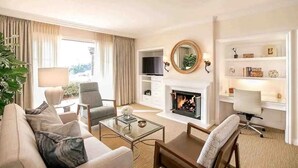 Una sala de estar con sofá, sillón, mesa de centro, chimenea, televisor y estantería.