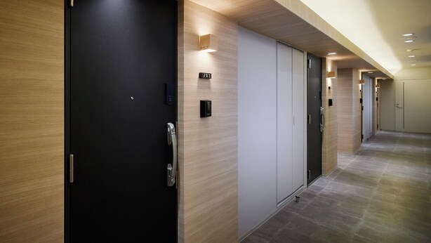 Un pasillo con varias puertas, algunas con números que indican los números de habitación.