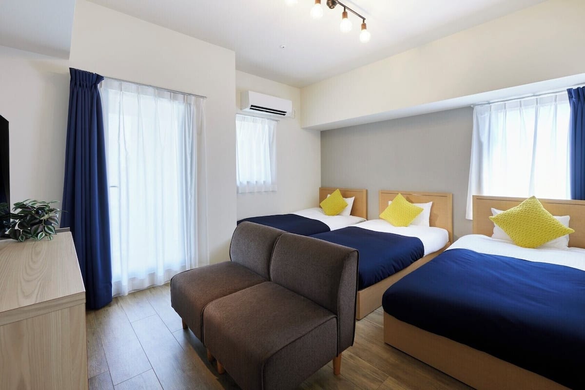 Une chambre d’hôtel avec deux lits, une télévision, un bureau et une chaise.