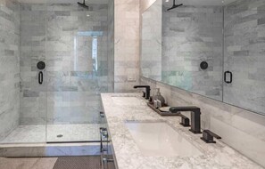 Enjoy a refreshing shower in this bathroom with a glass-enclosed shower area and a large mirror above the sink.