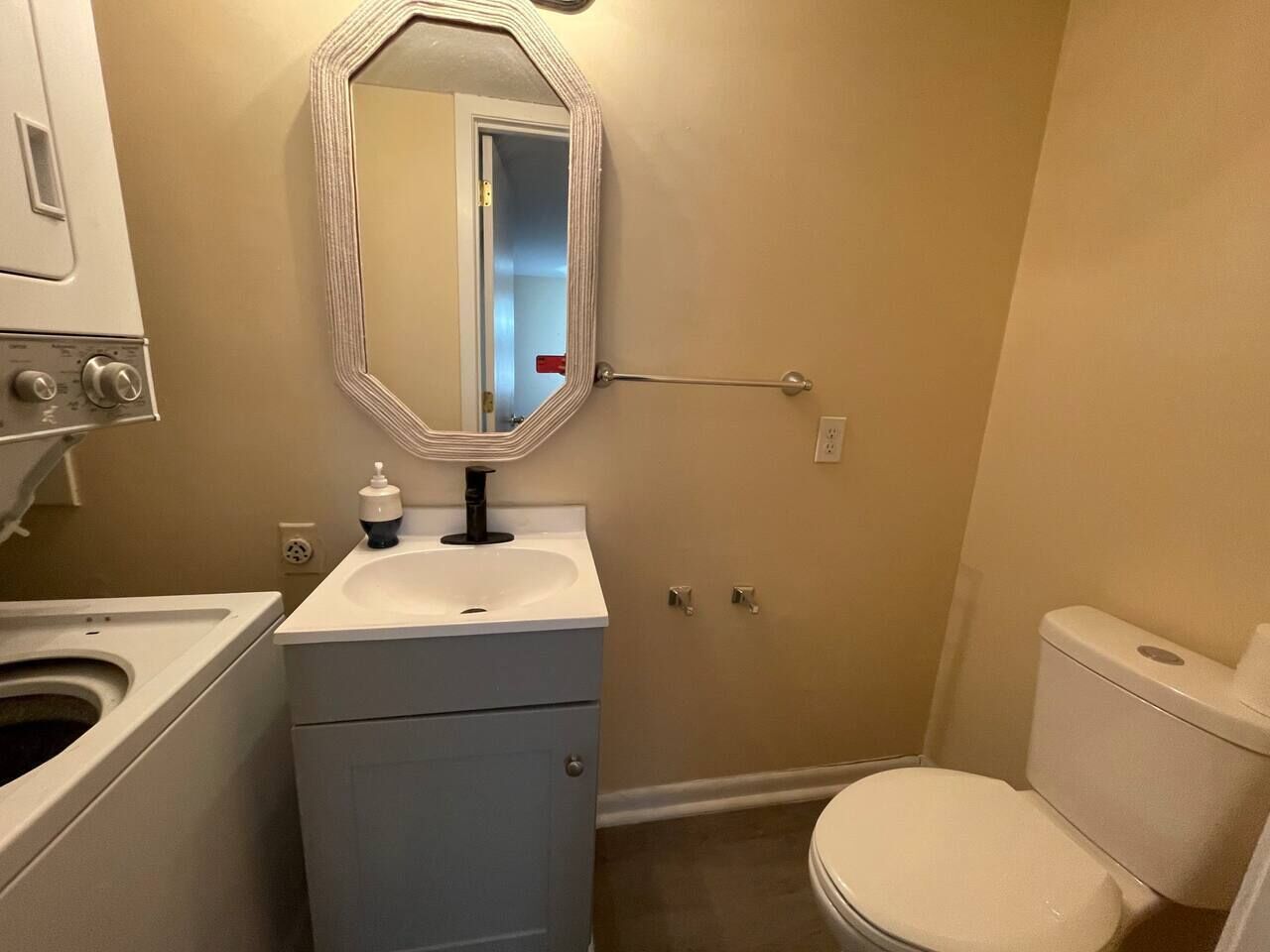 Ein kleines Badezimmer mit Toilette, Waschbecken und Waschmaschine.