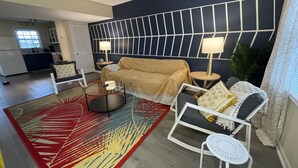 A living room with a sofa, two side tables with lamps, a coffee table, and a patterned rug.