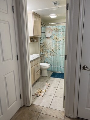 Ein Badezimmer mit Toilette, Waschbecken und einer Duschvorhang mit Muschel- und Sternfischmuster.