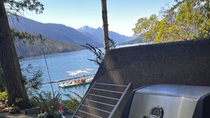 A portable Broil King grill with a control panel, set up outdoors with a view of a lake and mountains in the background. - Pet-Friendly Sproat Lake Suite | Private Dock, Paddleboard/Kayaks, Firepit (Port Alberni)