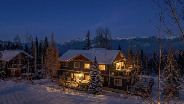 Ein großes Chalet mit mehreren Ebenen und verschneiter Landschaft.