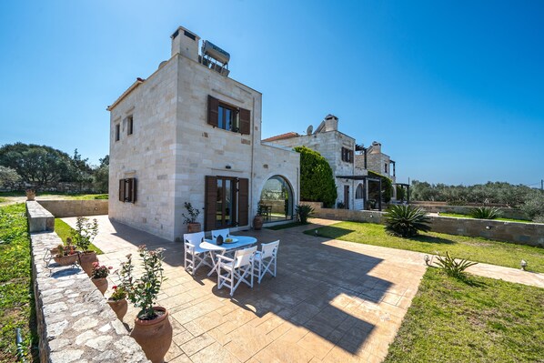 A stone building with a patio, outdoor seating, and a garden. - Luxury Rural Escape (Pazinos)