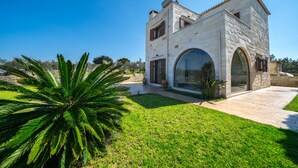 A stone building with a large arched doorway and a small balcony.