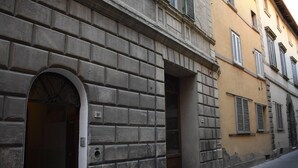 A building with a stone facade, a large arched doorway, and a narrow entrance.