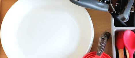 A kitchen drawer with various utensils and dishes.