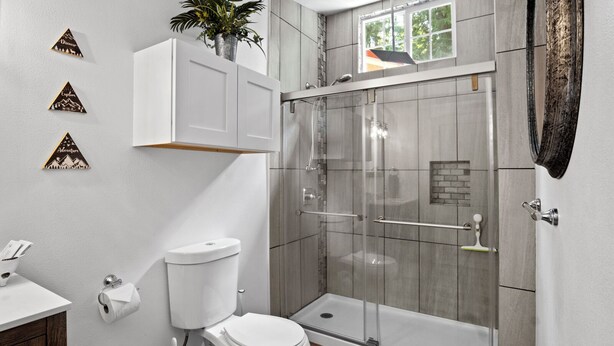 A modern bathroom with a toilet, shower, and sink. - Tiny Cabin B, Steps from Mt. Rainier Nat Park W/ firepit close to river & trails (Ashford)