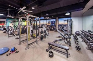 Work out in style with a fully equipped gym featuring exercise machines, free weights, and a bench.