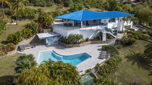 A modern house with a swimming pool, a covered patio, and a staircase leading to the upper level. - 3 Villas,One Price/ Sleeps 16/ Steam Room/Private Pool/Close to everything Gated (St Thomas)