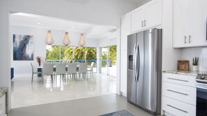 A modern kitchen with white cabinets, a stainless steel refrigerator, and pendant lights. - 3 Villas,One Price/ Sleeps 16/ Steam Room/Private Pool/Close to everything Gated (St Thomas)