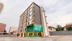 A multi-story hotel with a modern design, featuring a prominent entrance with glass doors and a green awning. - B2 Khon Kaen Premier Hotel (Khon Kaen)