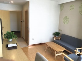 A modern living room with a sofa, a coffee table, and two potted plants.