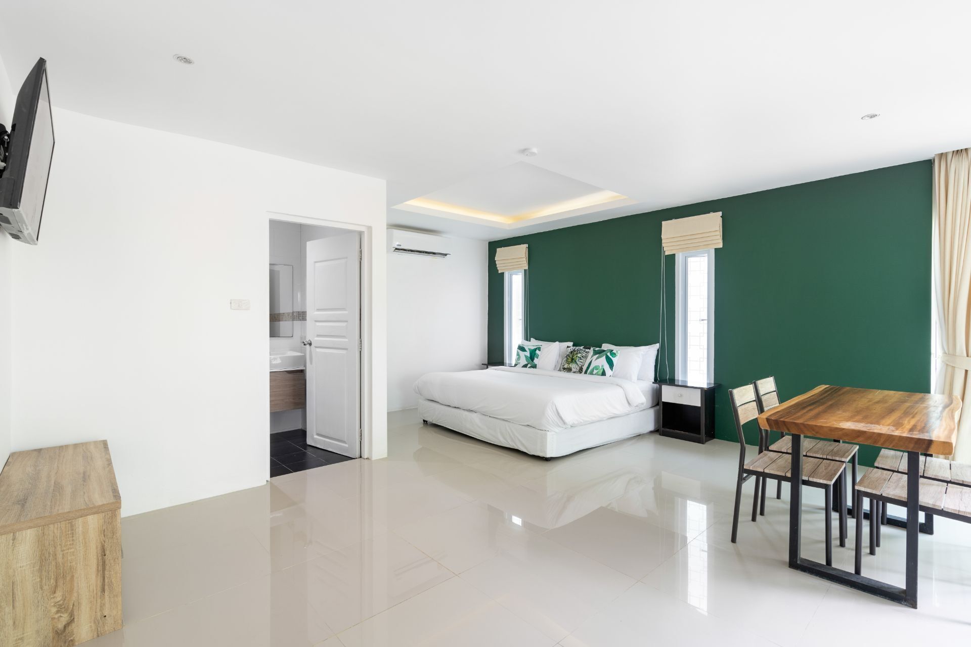 Een moderne hotelkamer met een groot bed, een eettafel en een aparte badkamer.