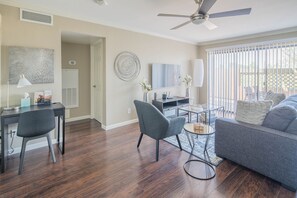 Relax in this inviting living room with a comfortable sofa, ceiling fan, and large window.