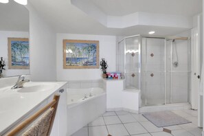 A modern bathroom with a bathtub, a shower, and two wall-mounted sinks.