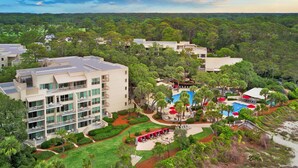 Un resort con varias edificaciones, una piscina y jardines bien cuidados.