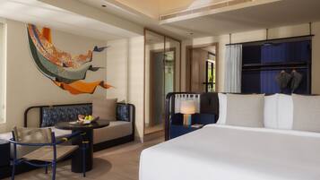 Una habitación de hotel moderna con una cama grande, un sofá, una mesa de comedor y un mural decorativo en la pared.