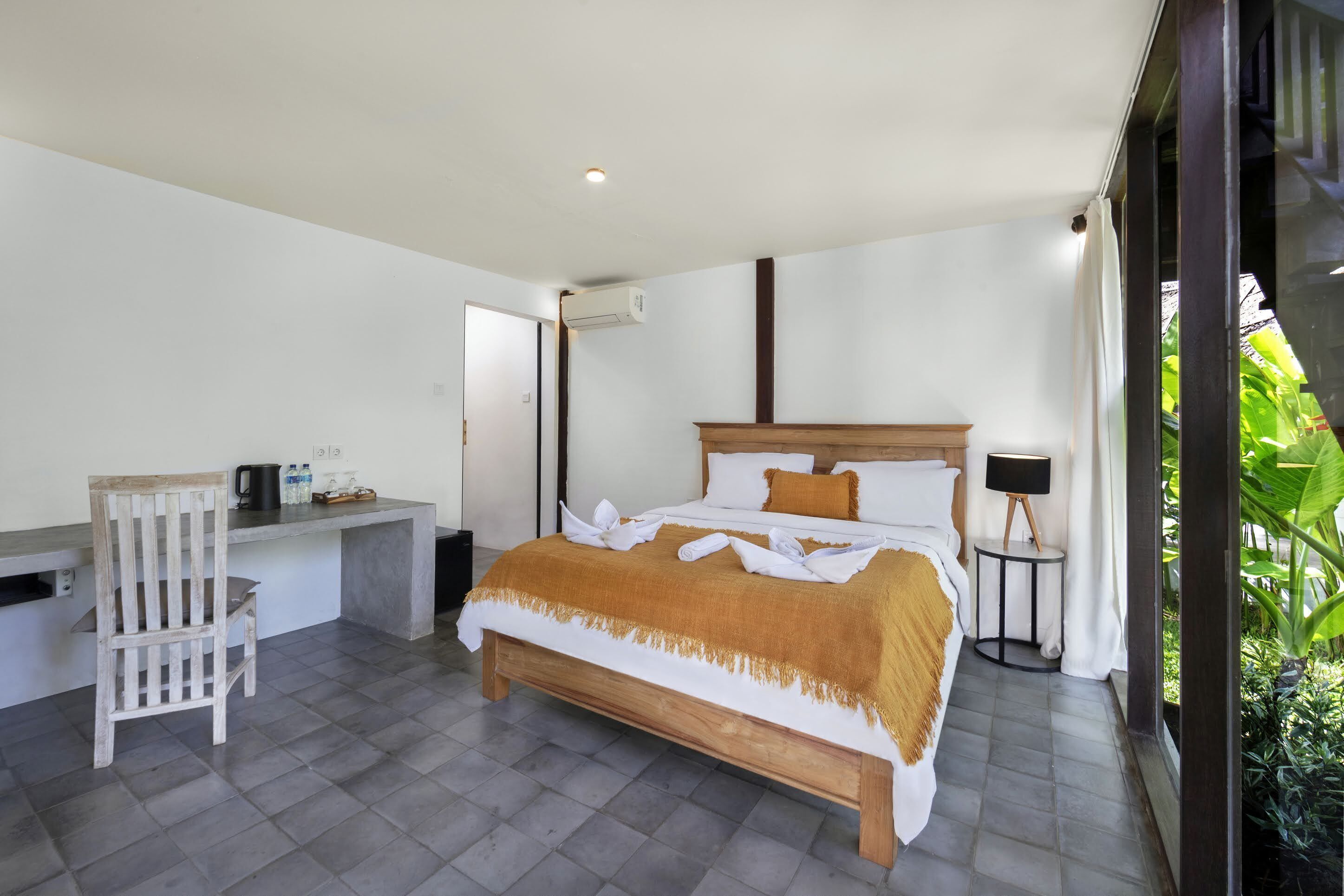 A modern bedroom with a bed, a desk, and a small table.