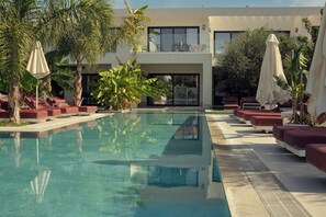 Una piscina al aire libre, tumbonas