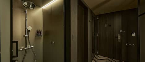 Un baño moderno con ducha, tocador y espejo.
