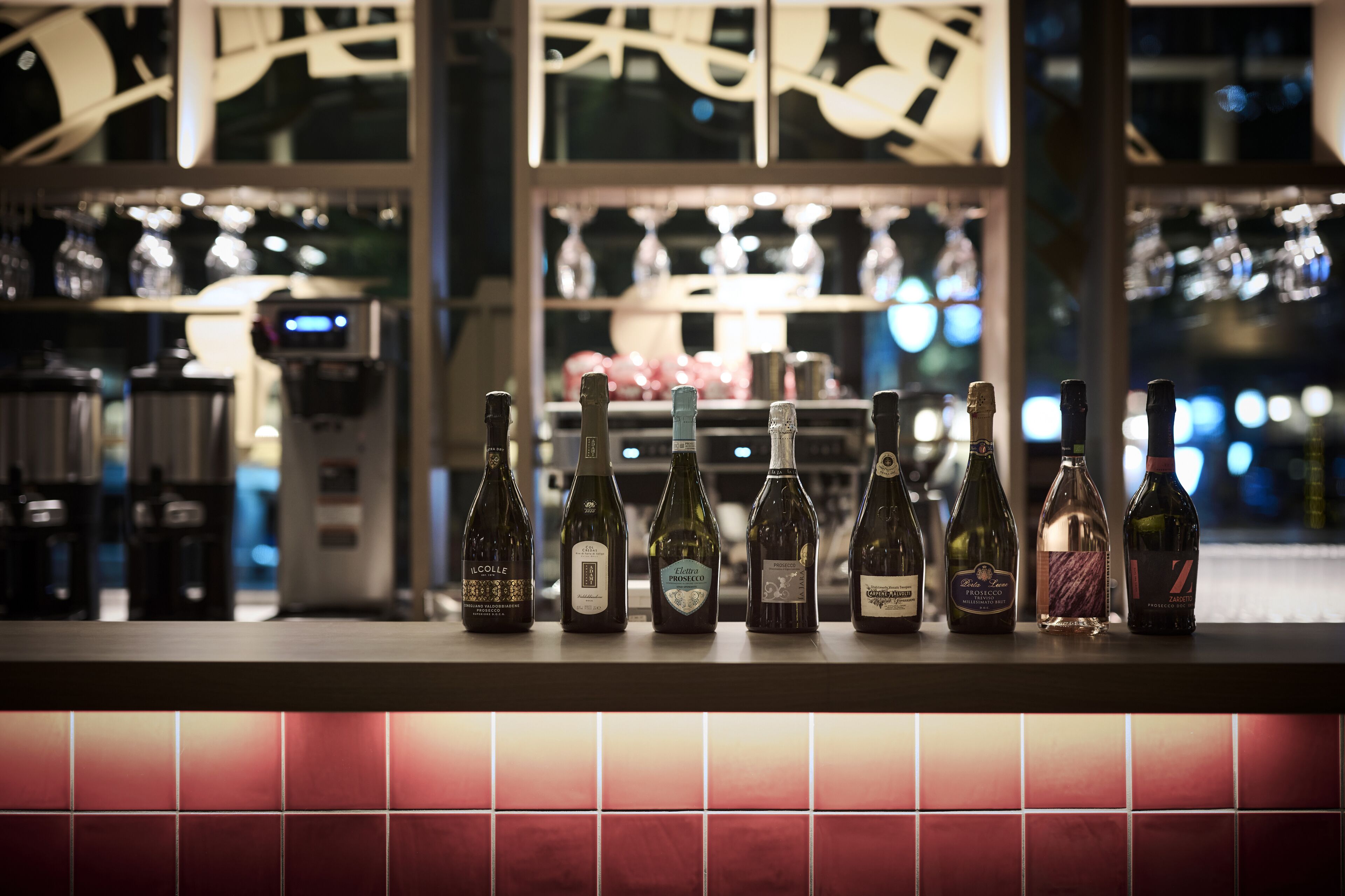 Una barra con varias botellas de vino y una máquina de café.