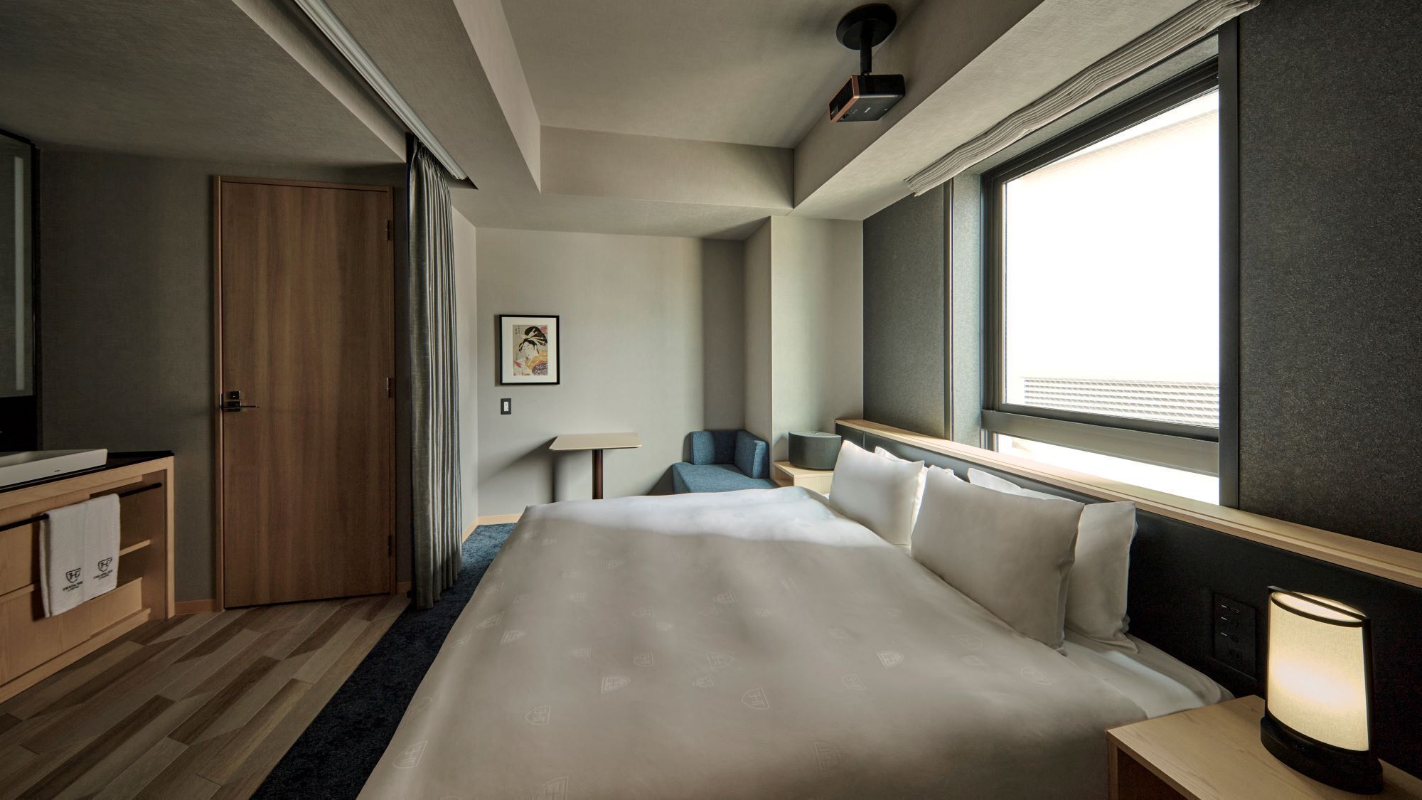Een hotelkamer met een bed, bureau, stoel, lamp en raam.