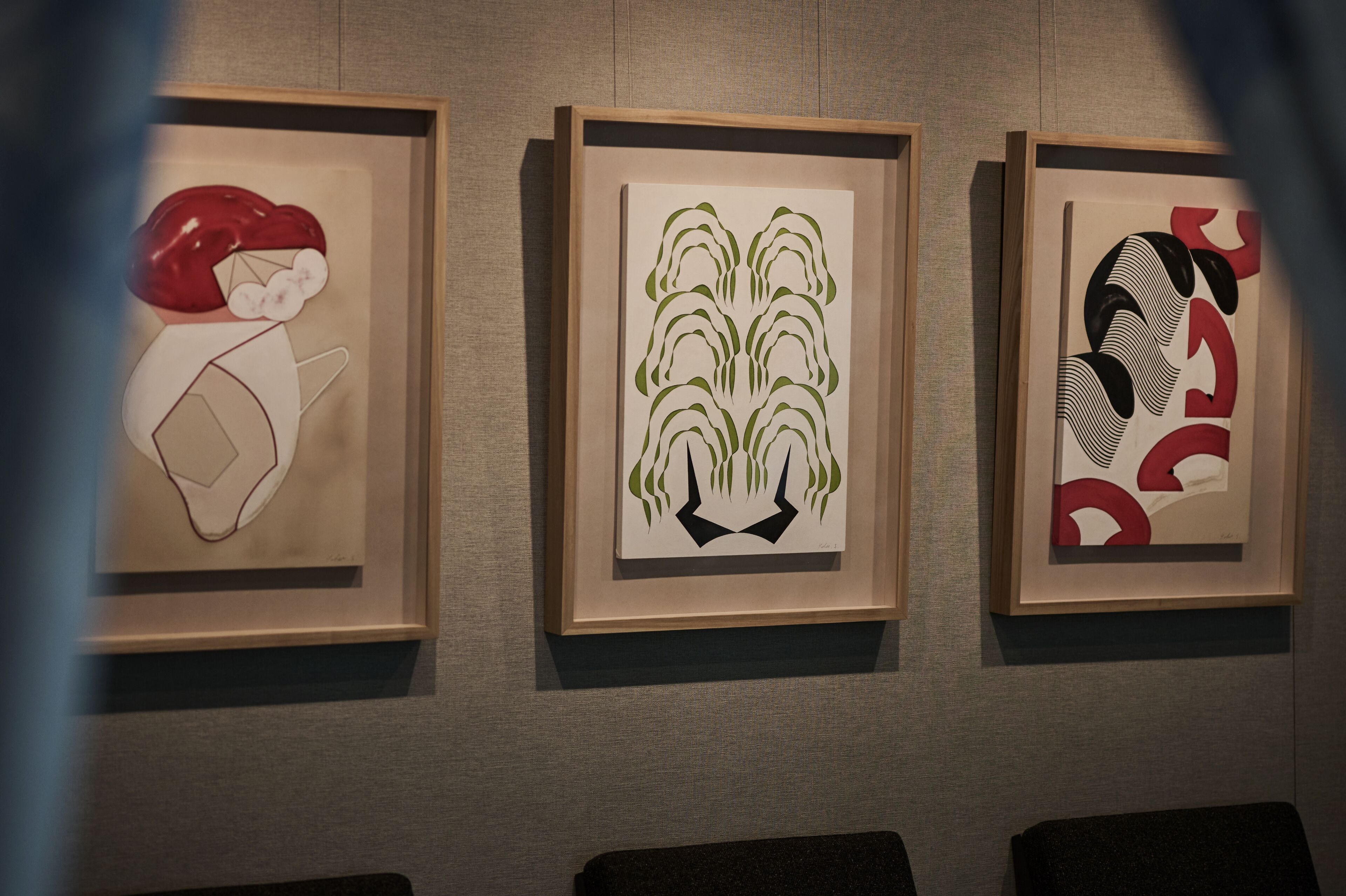 Three framed artworks on a wall.