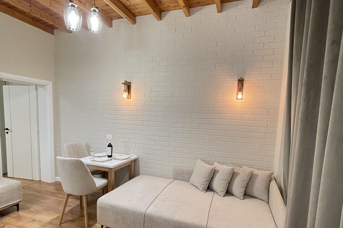 Appartamento Deluxe, balcone, vista mare parziale | Area soggiorno | Smart TV 32 pollici con canali via cavo, TV