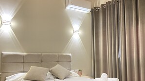 Ein ordentlich bezogenes Bett mit Kissen und Handtüchern, ein Kopfteil und eine Holzbalkendecke.