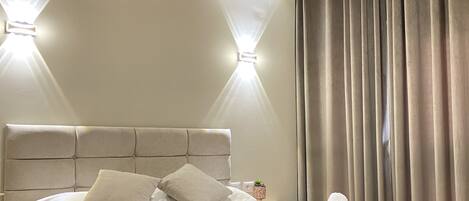 A neatly made bed with pillows and towels, a headboard, and a wooden ceiling with exposed beams.