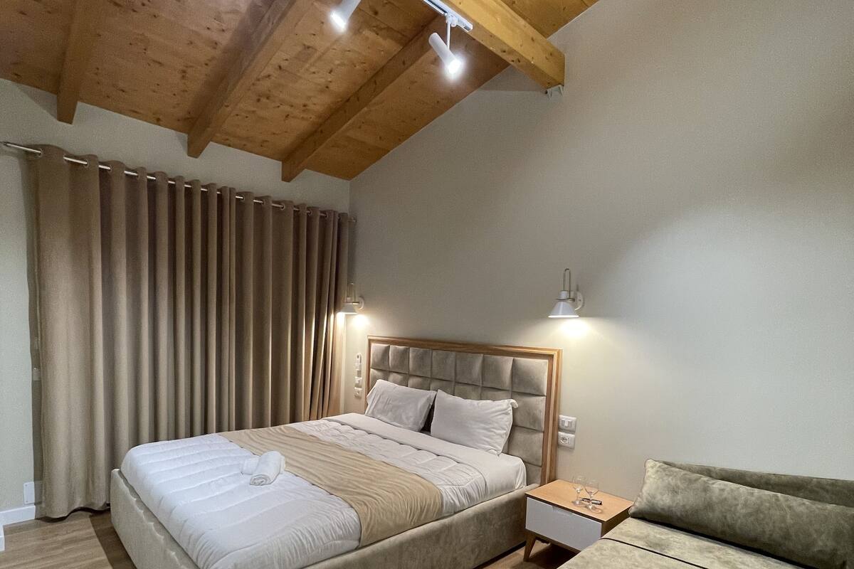 Ein Schlafzimmer mit Bett, Nachttisch und einer Couch.