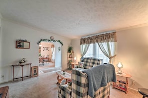 Relax in this inviting living space with a plaid sofa, armchair, and throw blankets.