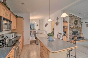 Enjoy cooking in this well-equipped kitchen with a central island, stainless steel appliances, and a dining area.