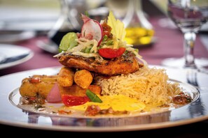 A plate of food with rice, vegetables, and a piece of meat. -  Delta Nature Resort (Somova)