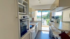 Eine moderne Küche mit integrierten Geräten, einem großen Fenster und einem Balkon.