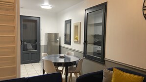 Un espace de vie compact comprenant un coin repas, un canapé et un réfrigérateur.
