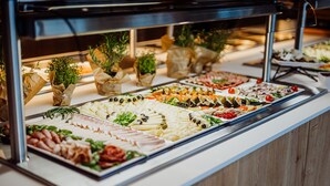 A buffet with various food items and decorative plants. - Elements Hotel Spa (Swieradow-Zdroj)