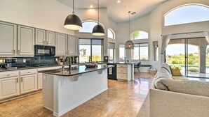 A spacious kitchen with a large island, white cabinetry, and a view of the outdoors. - Spa, Putting Green! Family Haven in Fountain Hills (Fountain Hills)