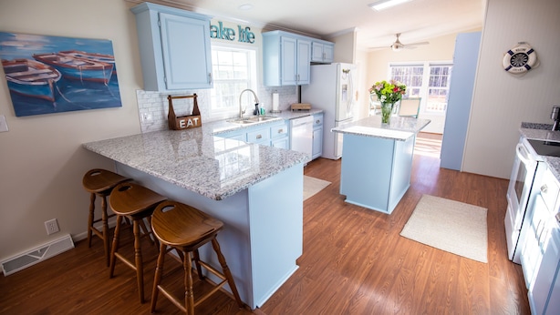 A kitchen with light blue cabinets, a granite countertop, wooden stools, and a painting of boats. - Lake Murray Lake Views Galore (Prosperity)