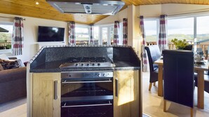 A modern kitchen with a built-in stove, oven, and ventilation hood. - Lovely 3-bed House in Carnforth (Carnforth)