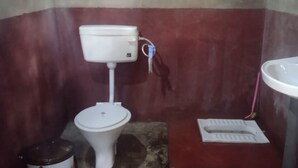 Pieni kylpyhuone, jossa on wc, pesuallas ja bidee.
