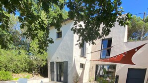 Ein modernes Haus mit Terrasse, einer Hängematte und Gartenmöbeln.