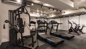 Un gimnasio con cintas de correr, elípticas y máquinas de pesas.