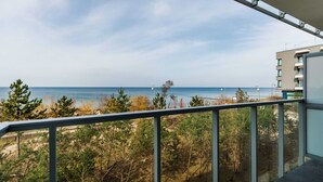 Un balcón con vista al mar y la vegetación de la playa.